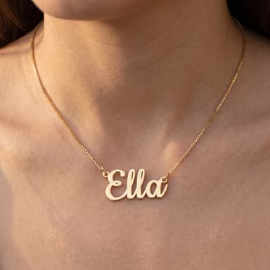 Scale shot: dainty gold plated name necklace on a model's collarbone, full chain visible