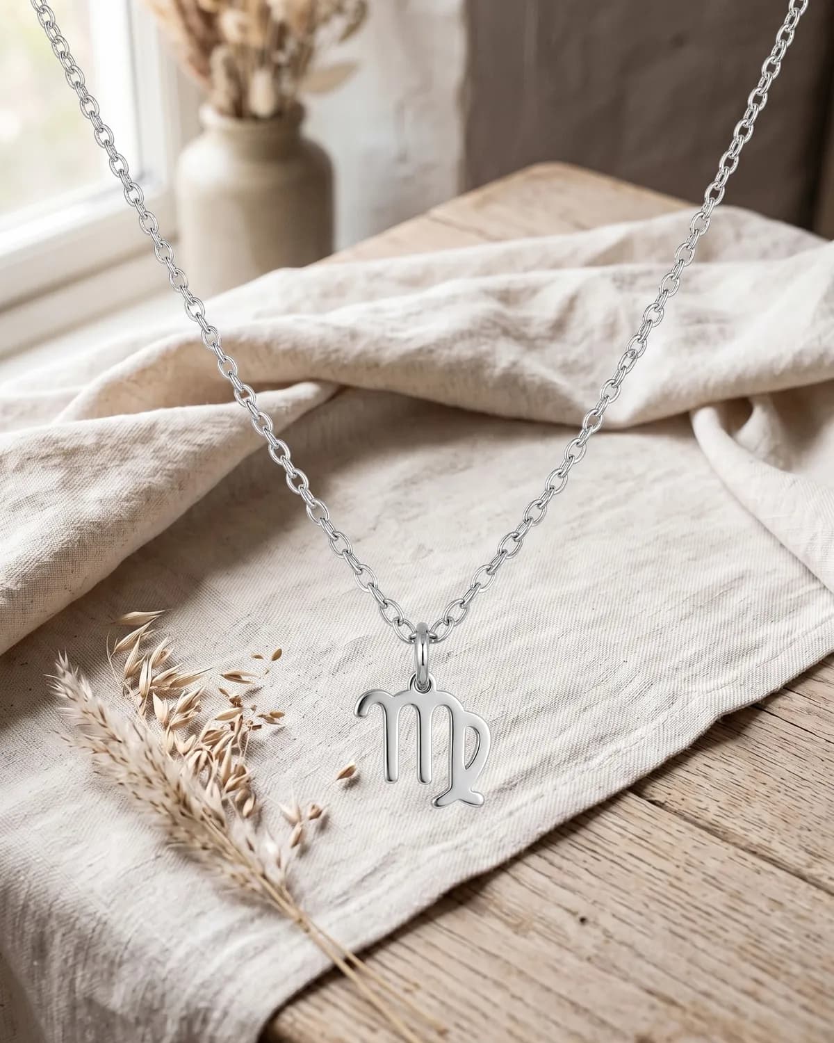 A 925 sterling silver Virgo necklace on ivory linen