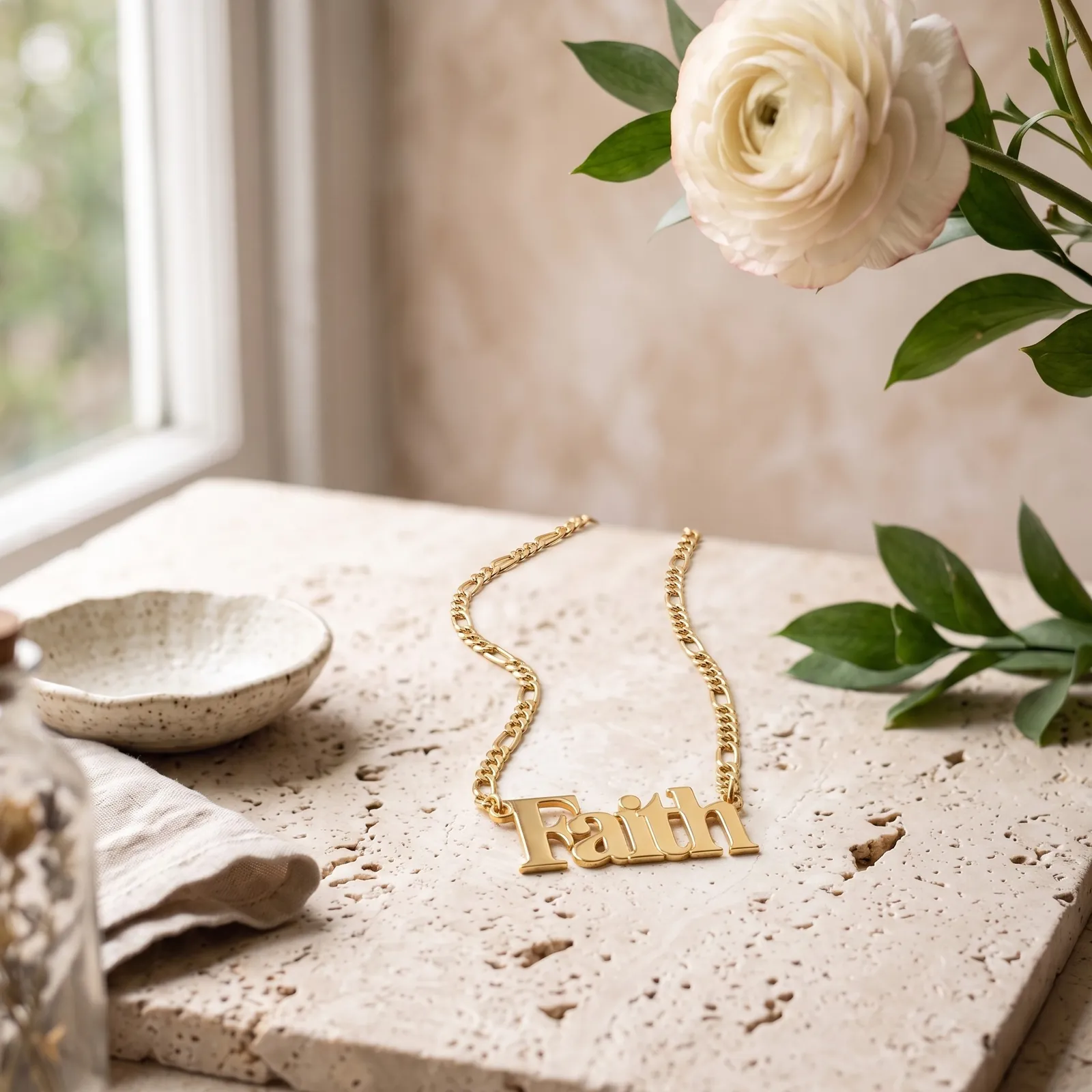 A gold plated “Faith” necklace on pale travertine