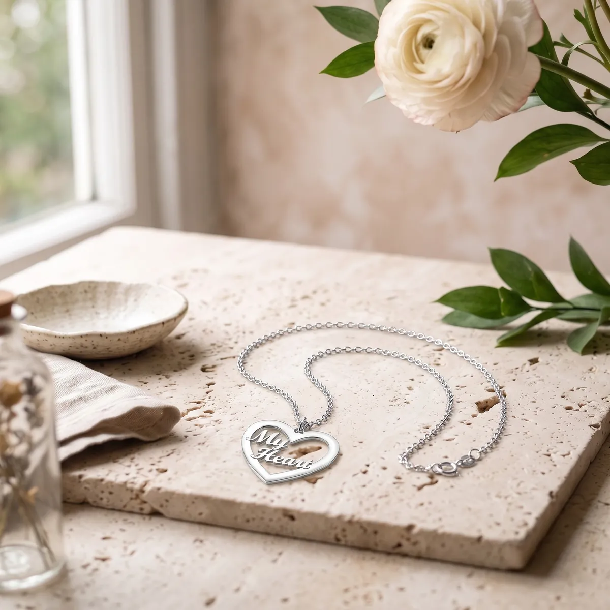 A 925 sterling silver “My Heart” necklace on pale travertine